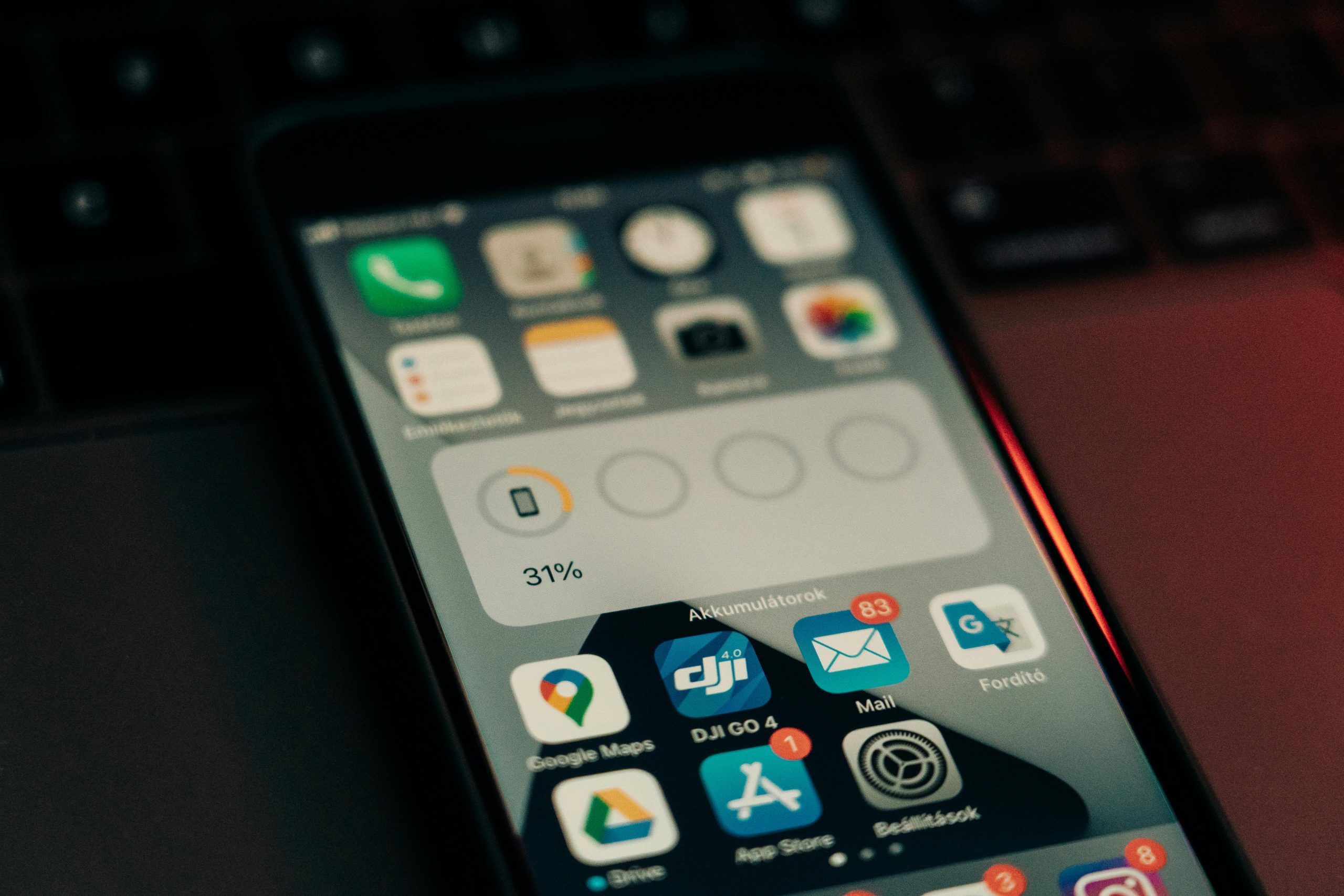 A smartphone with various apps on its screen placed on a keyboard, showing a 31% battery level.