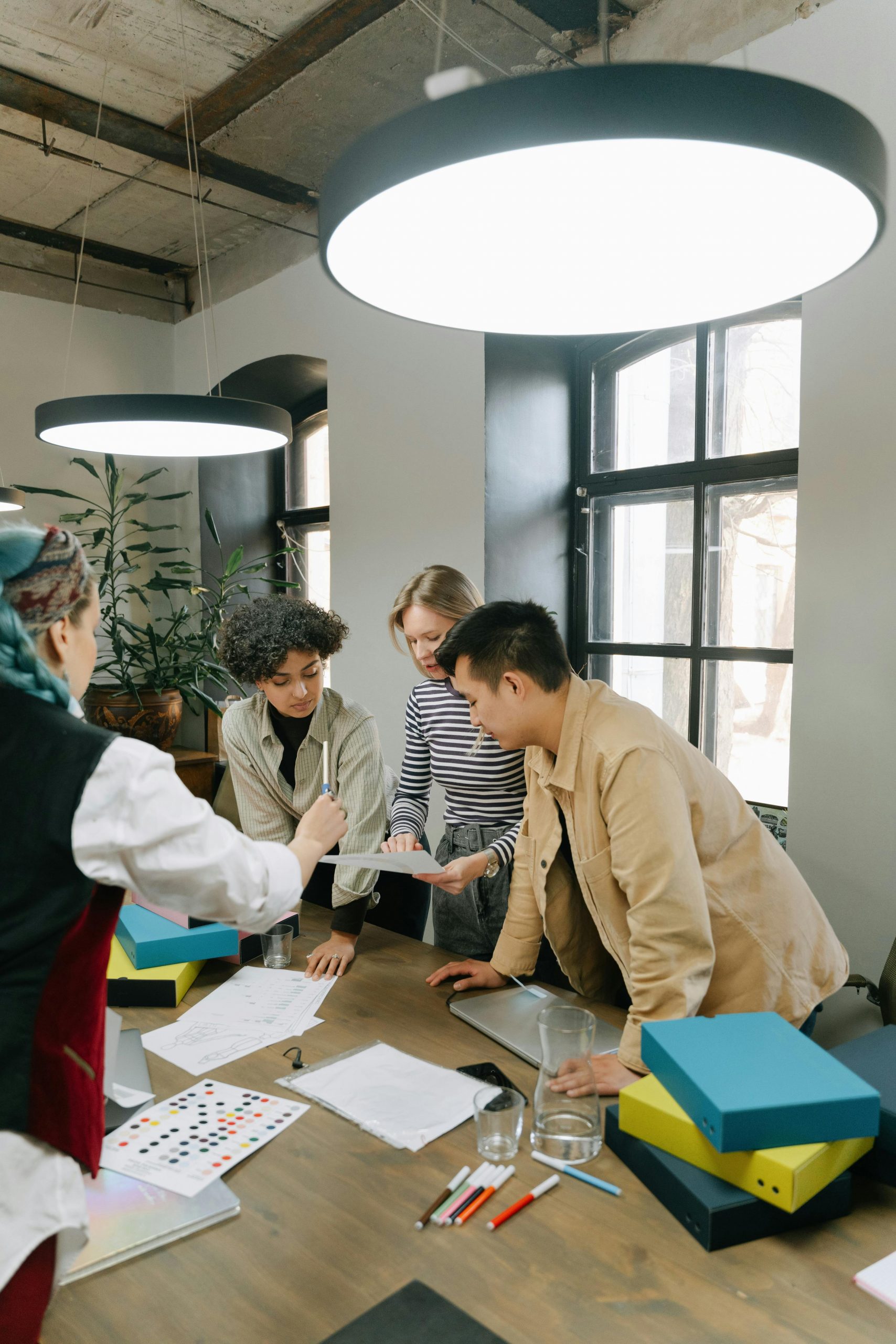 Diverse team of young professionals brainstorming together in a contemporary office setting.